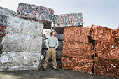 工人站在成堆的回收材料旁边图片素材