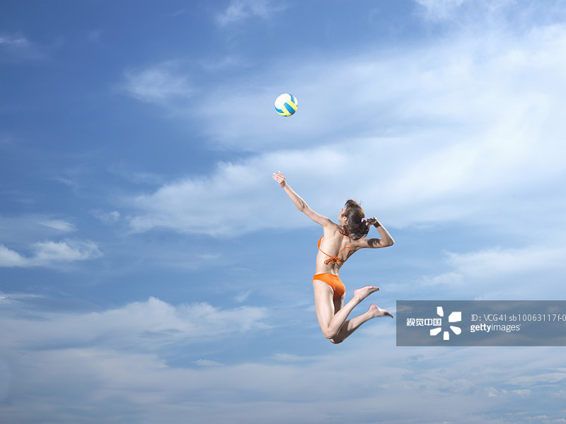 一名年輕女子在空中擊打排球圖片素材