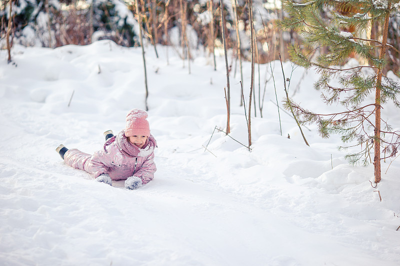 可愛的快樂小女孩在冬天下雪的雪橇圖片素材