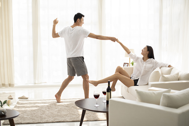 年輕情侶在客廳跳舞圖片素材