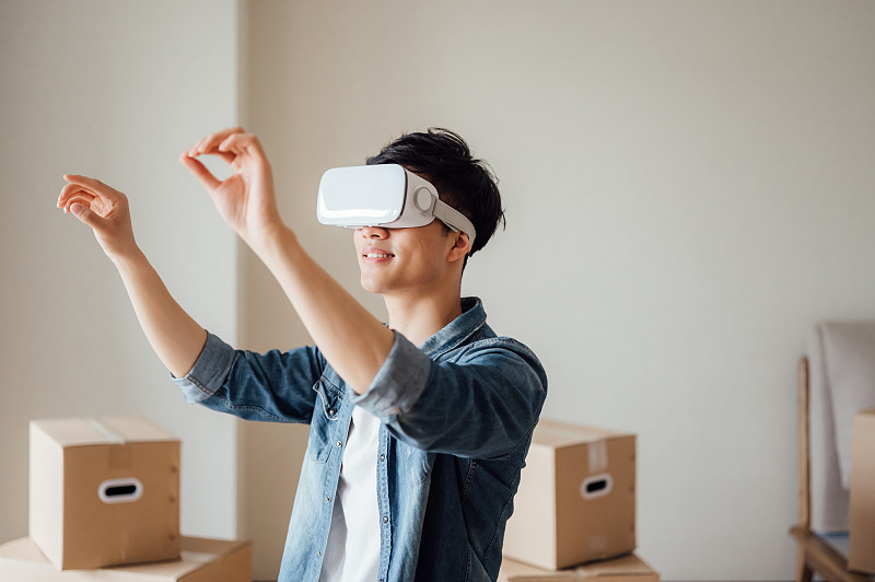 亞洲年輕男孩在新家使用VR眼鏡圖片素材