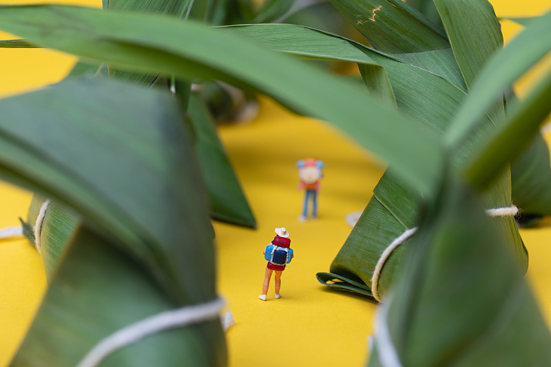 端午節-粽子與背包人物模型在黃色背景上圖片素材