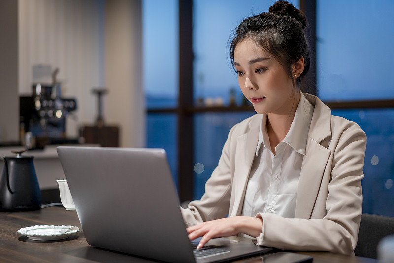 一個亞洲年輕女性在夜晚的辦公室加班圖片下載