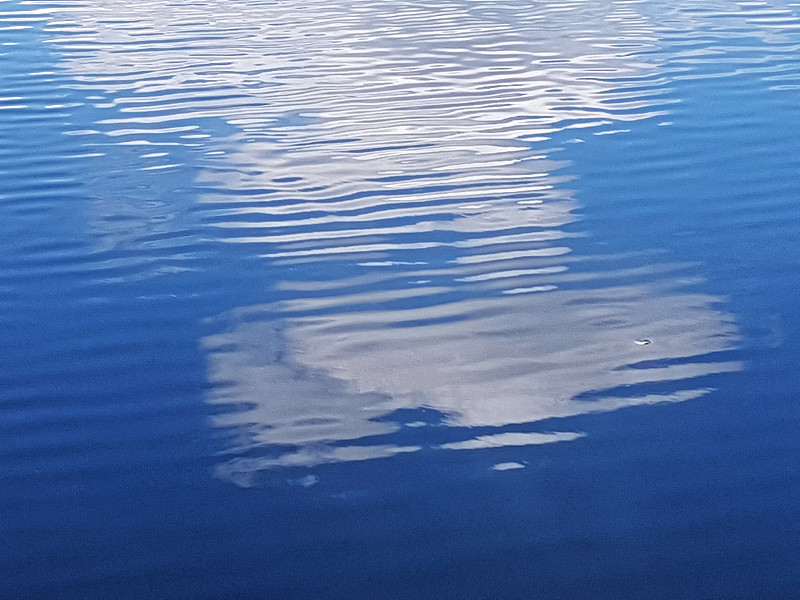 大云的倒影在漣漪的水面上的池塘，完整的框架圖片素材