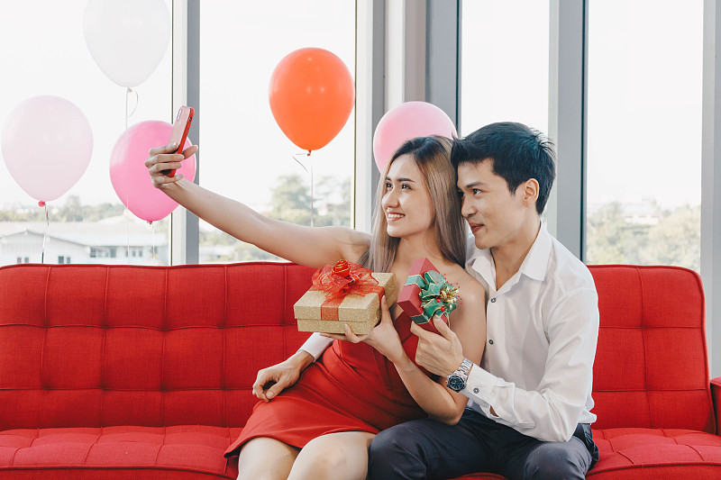 一對年輕的亞洲夫婦用手機一起自拍，這是情人節的概念。圖片下載