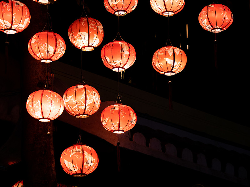 許多顏色的會安越南中國風格的燈籠在城市的街道上展示。古色古香的彩燈在街道對面閃耀。建立東南亞工藝美術旅游區攝影圖片