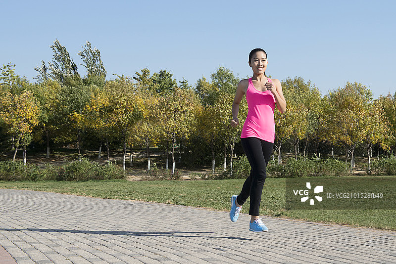 Young woman jogging in park图片素材