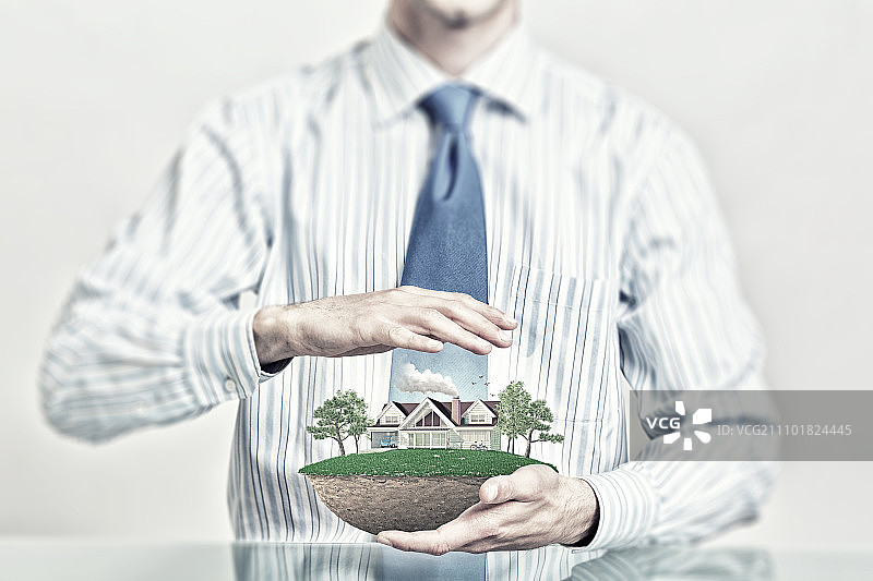 生态建设模式。商人的双手抱着关怀的绿色生活理念图片素材