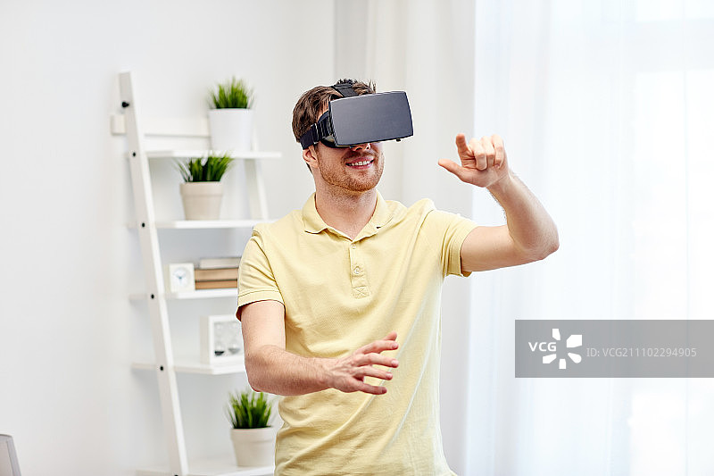 技术、游戏、娱乐和人的概念——快乐的年轻人用虚拟现实头盔或3d眼镜玩视频游戏图片素材