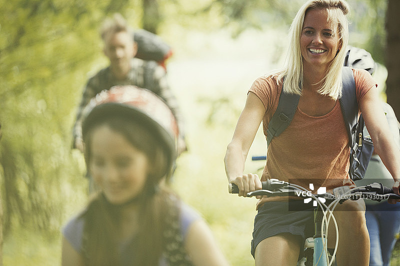 全家人微笑着在树林里骑山地自行车图片素材