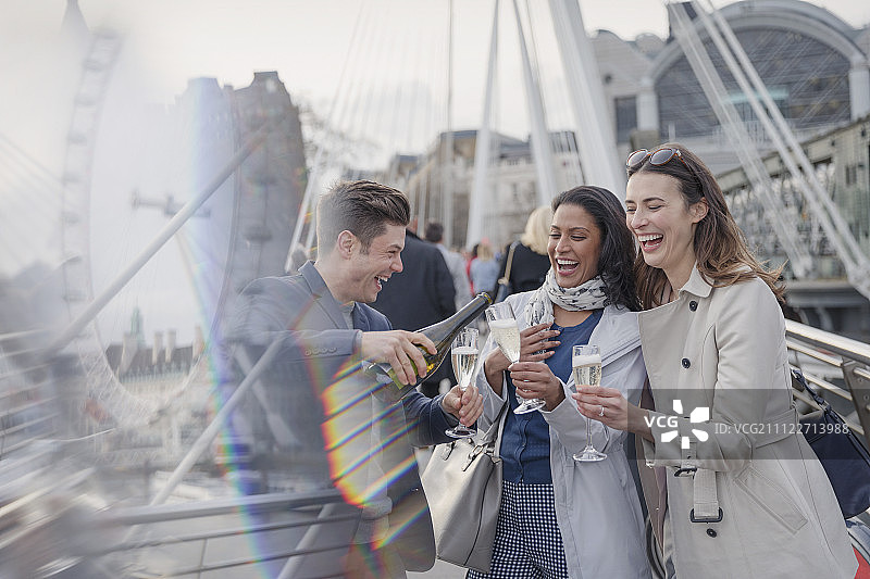 微笑，快乐的朋友庆祝，倒香槟在城市，伦敦，英国图片素材