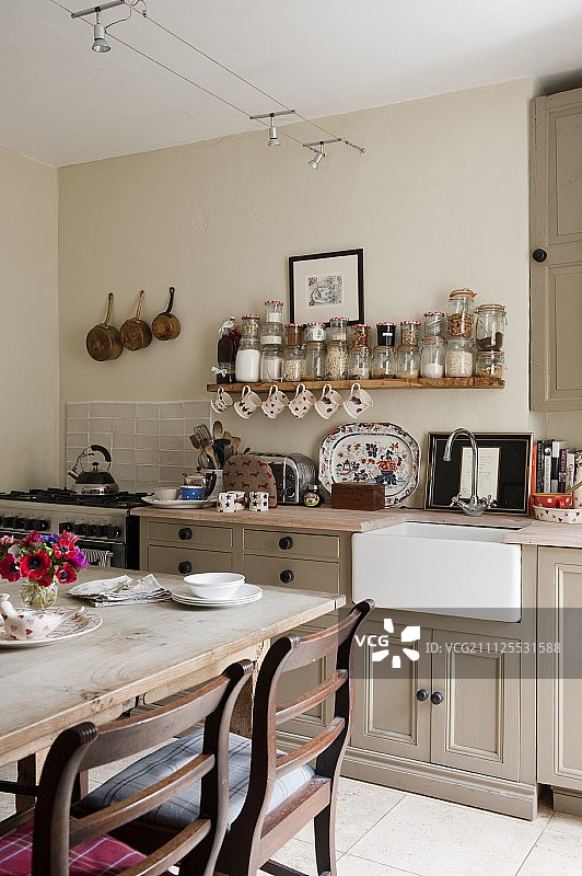 用餐区在厨房柜台前面，在英国乡村厨房的开放式香料架下面图片素材