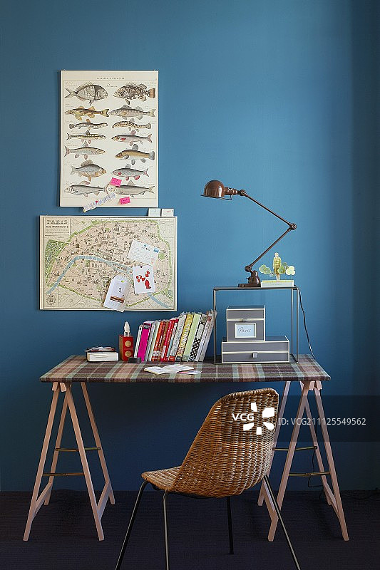 桌面覆盖着格子布和木制支架，灰色纸箱，书，台灯和旧地图图片素材