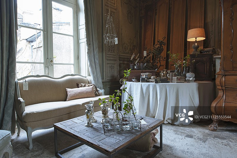 在一个古老的法国乡村住宅的客厅里，客厅家具和古董风格的配件的销售展览图片素材