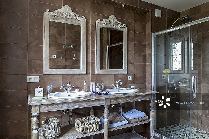复古风格的盥洗台有两个水槽和华丽的镜子旁边的玻璃淋浴区图片素材