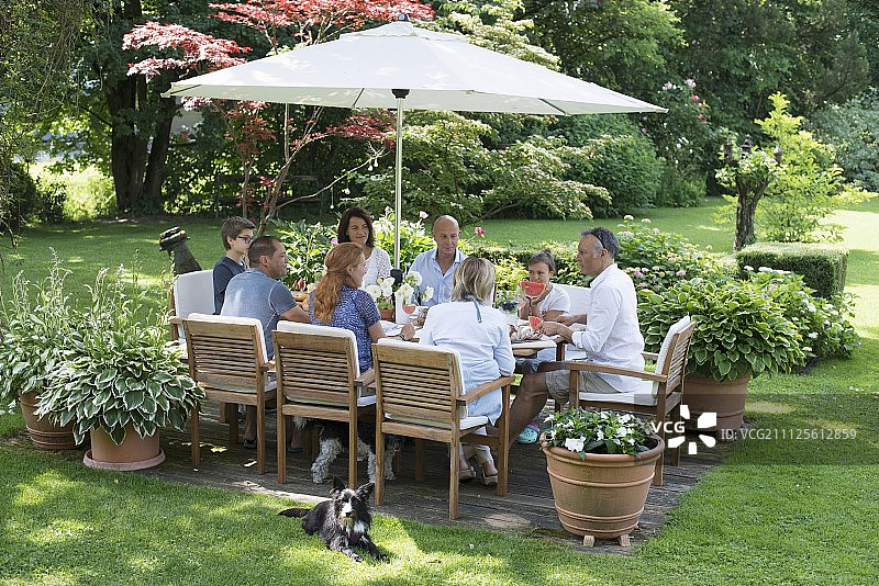 客人周围设置餐桌与集成阳伞花园图片素材
