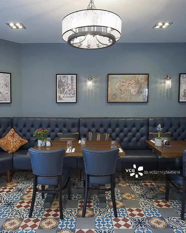 复古餐厅里的蓝色装饰地砖上的皮革长凳和椅子图片素材