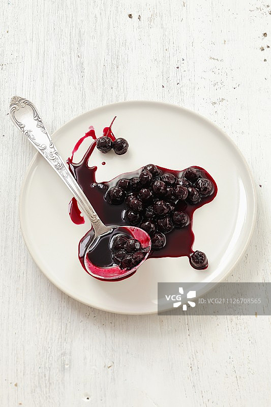 用长柄勺舀在盘子里的一团野莓果酱图片素材