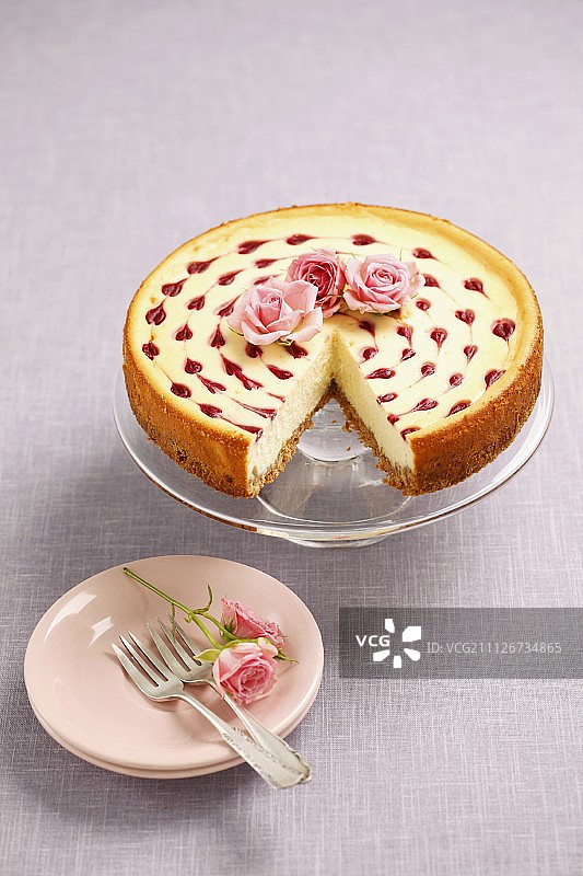 芝士蛋糕配覆盆子酱和玫瑰装饰图片素材