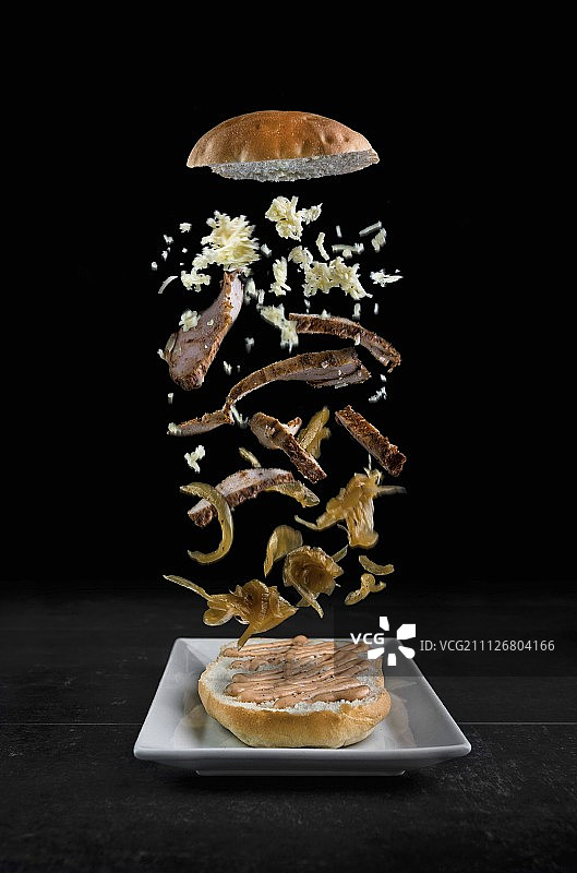 烤鸡胸肉，焦糖洋葱和磨碎的莫札雷拉奶酪落在盘子上图片素材