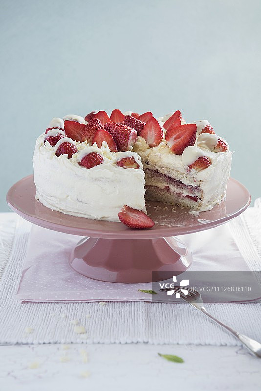 蛋糕架上的白巧克力草莓蛋糕，切片图片素材
