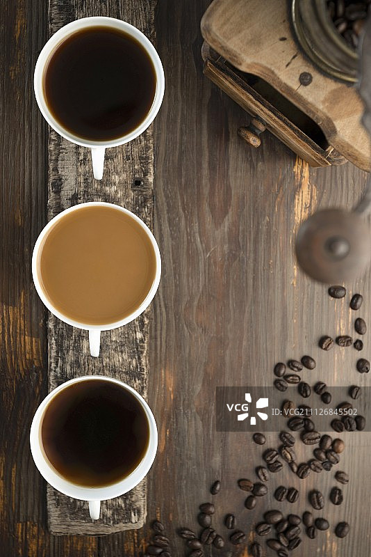 咖啡的安排，三杯咖啡，咖啡豆和一个咖啡研磨机图片素材