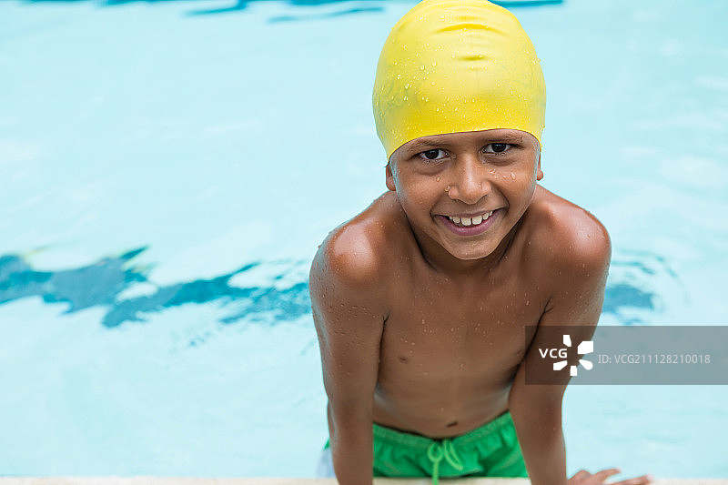 微笑的男孩站在游泳池的肖像图片素材