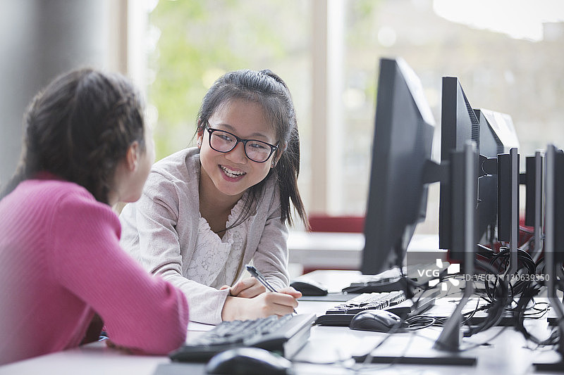 微笑的女学生研究计算机在实验室教室图片素材