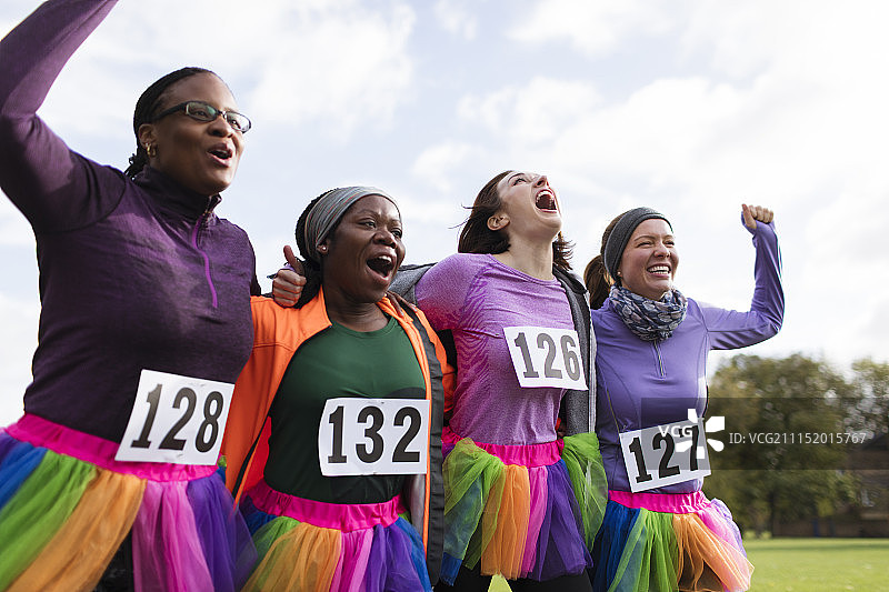 热情的女跑步者朋友们穿着短裙在慈善跑步时欢呼图片素材