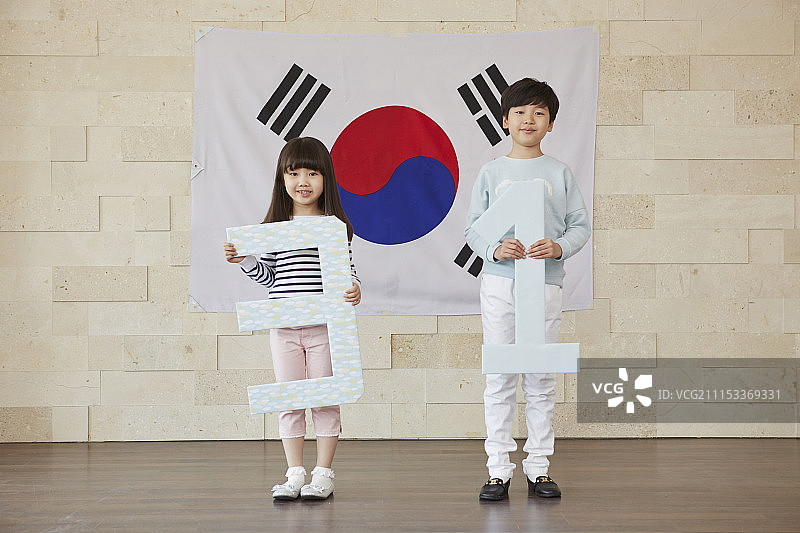 小男孩和小女孩手持3和1站在韩国国旗前的照片图片素材