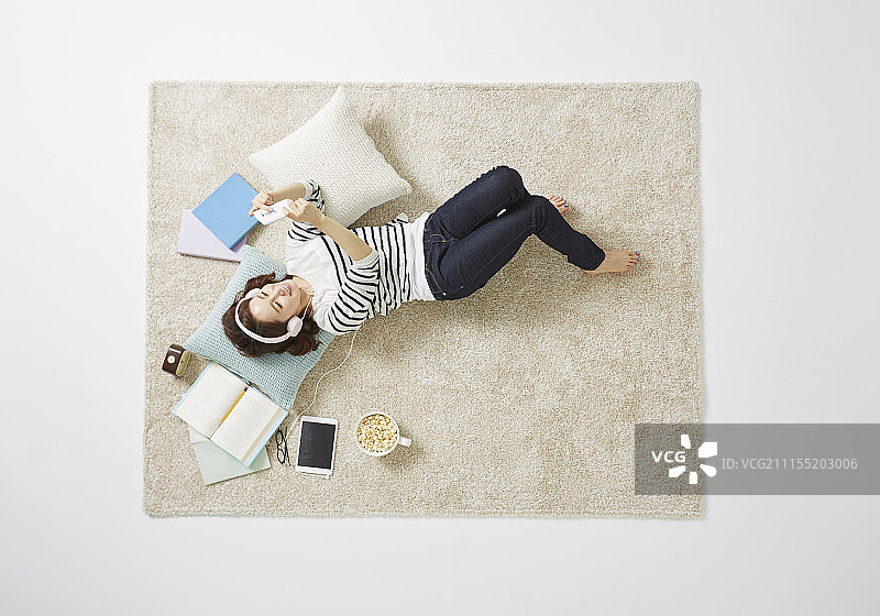 女人躺在地毯上休息的照片图片素材