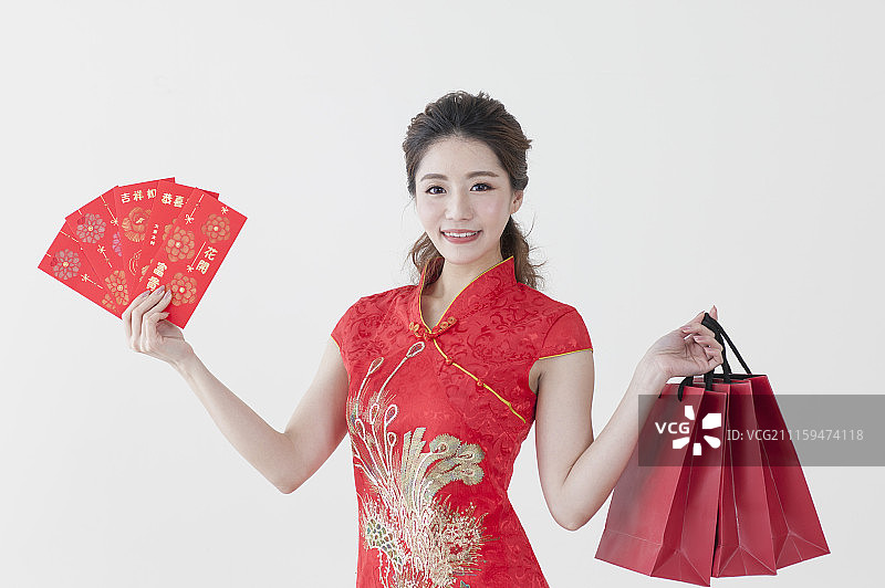 年轻女人穿旗袍拿着红包去购物图片素材