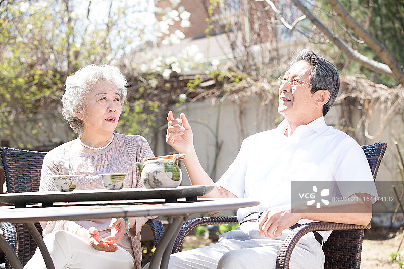 老年夫妇在庭院喝茶图片素材
