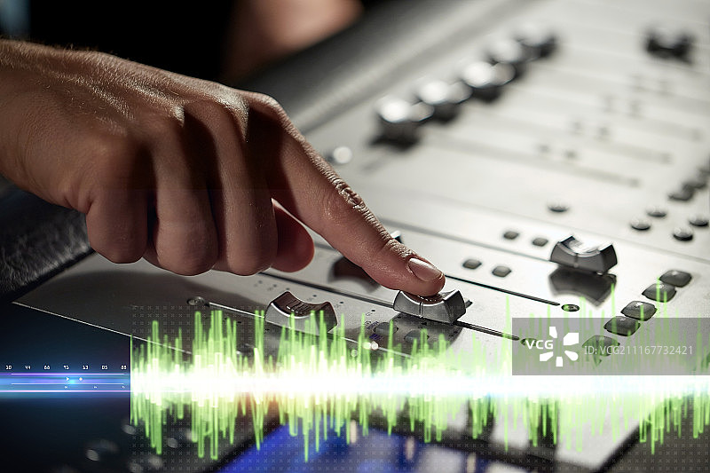 音乐，技术，人员和设备概念-手使用混音控制台在录音室。在音乐录音棚中手动混音控制台图片素材