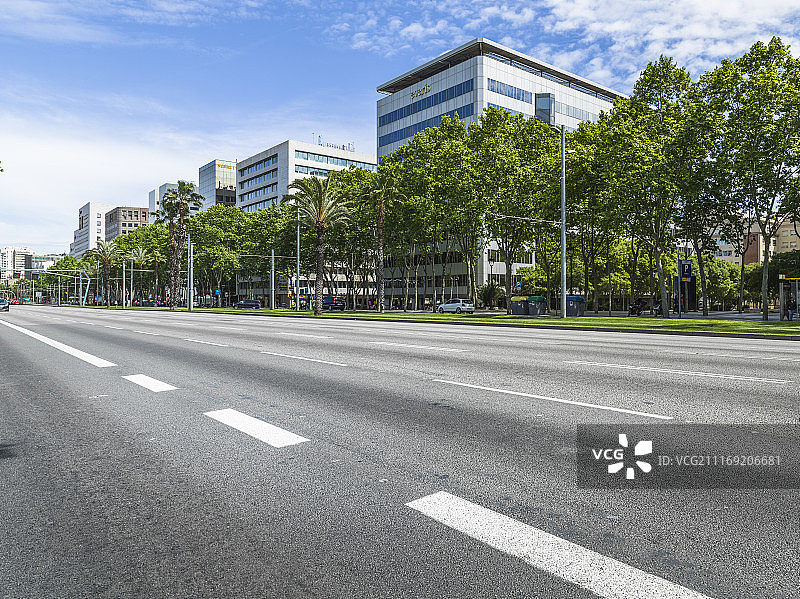 现代城市建筑旁有一条单行道多车道公路图片素材