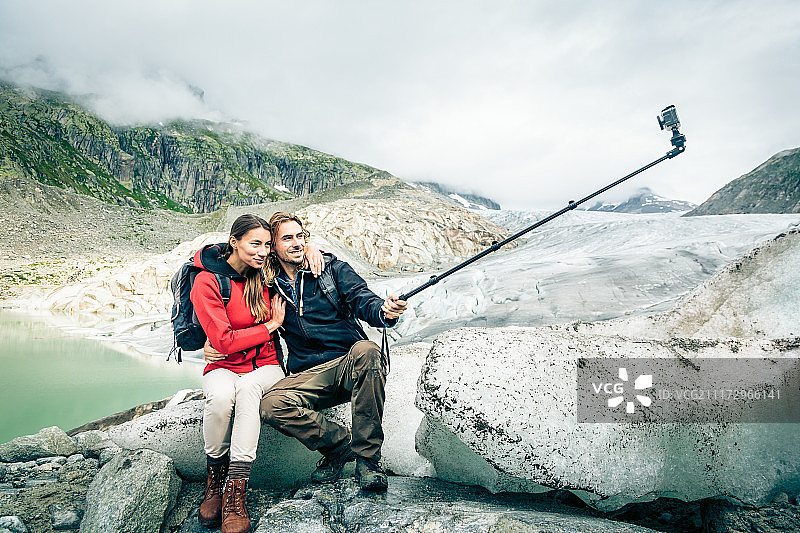 一对年轻夫妇在瑞士阿尔卑斯山徒步旅行，自拍图片素材