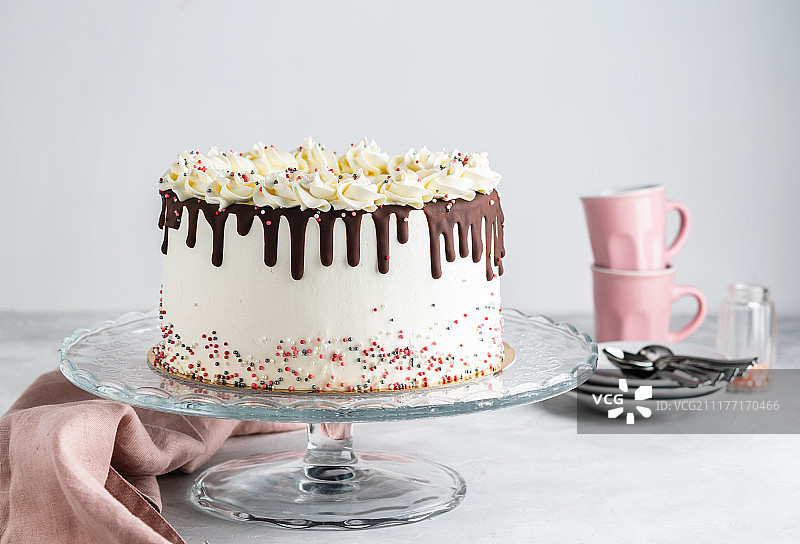 简单的生日蛋糕与巧克力甘纳许和点缀在一个白色的背景与派对图片素材