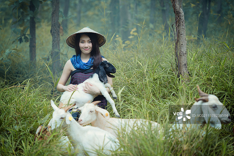 美丽的女人抱着幸福的羊穿着传统服饰图片素材