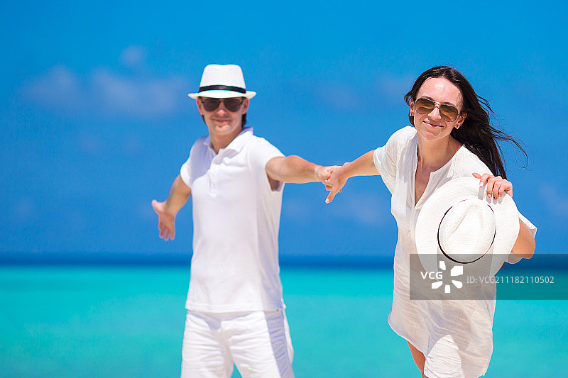 年轻快乐的夫妇在白色沙滩上的暑假图片素材