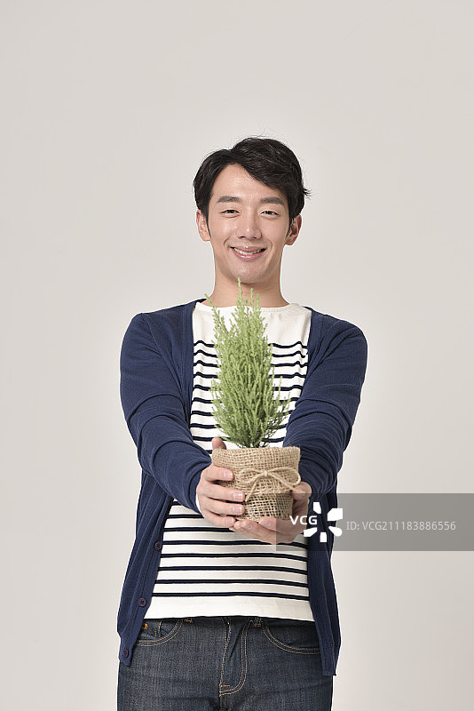 男人抱着植物的照片图片素材