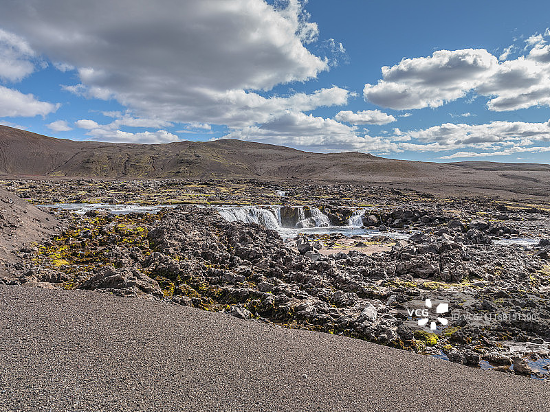后板显示了冰岛一条有山的小溪附近的岩石区域图片素材