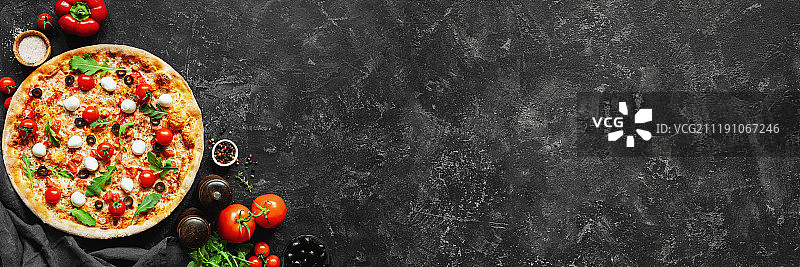 黑色混凝土背景下的意大利披萨和披萨烹饪配料图片素材