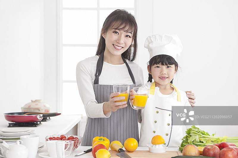 妈妈跟女儿在厨房喝果汁图片素材