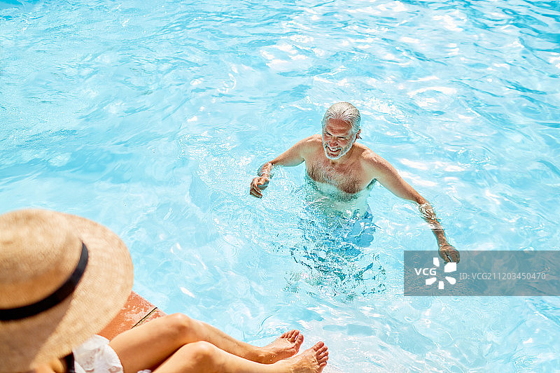 成熟的男人在阳光明媚的夏日游泳池里图片素材