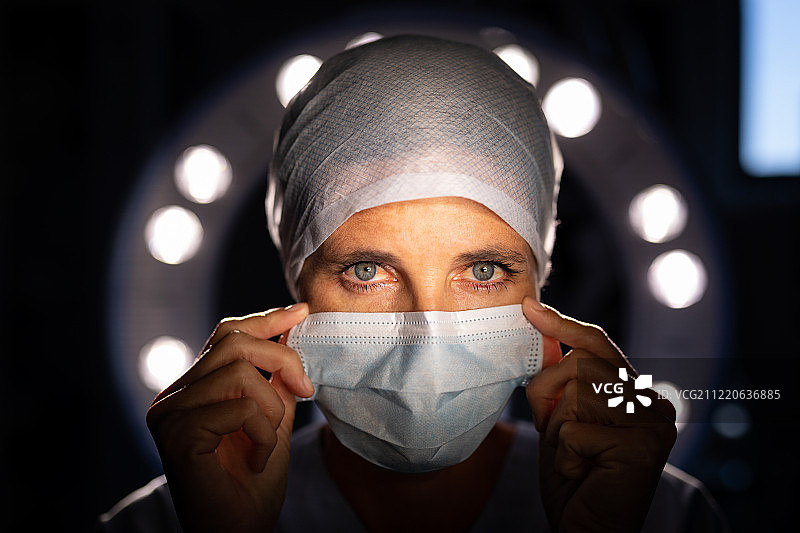 一位白人女外科医生在医院的手术室里看着摄像机的肖像图片素材