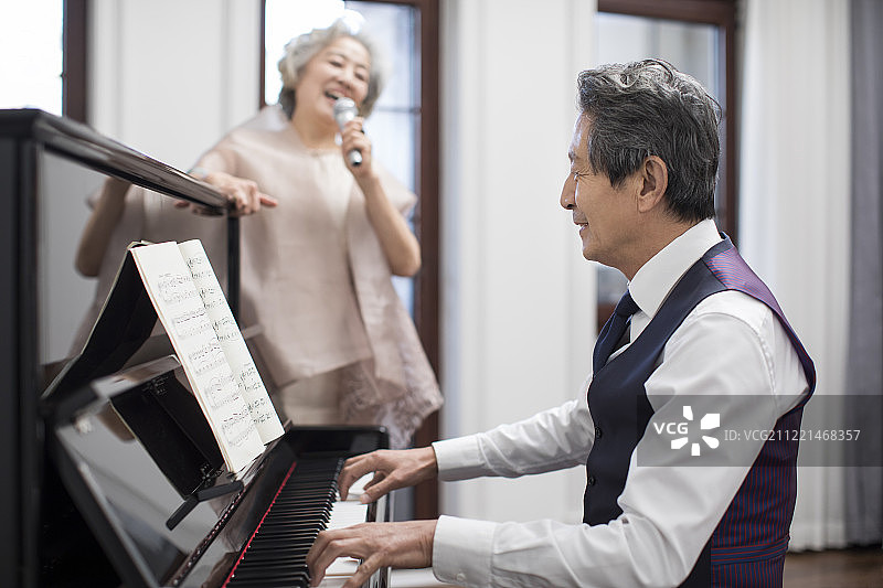 老年贵族夫妇一起唱歌弹钢琴图片素材