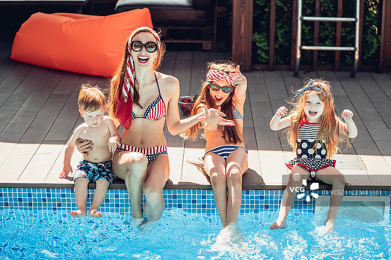 快乐的家庭在泳池边玩的时间图片素材