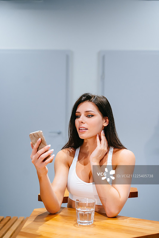 年轻女性锻炼后使用智能手机的生活方式图片素材