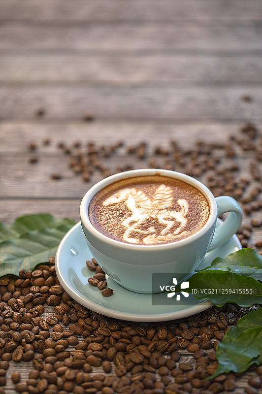 一杯含有漂亮拉花的拿铁咖啡和咖啡豆图片素材