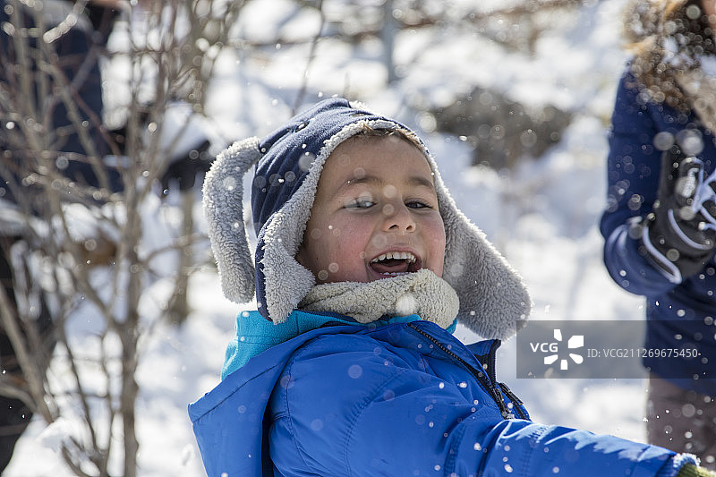 男孩在雪中玩耍图片素材